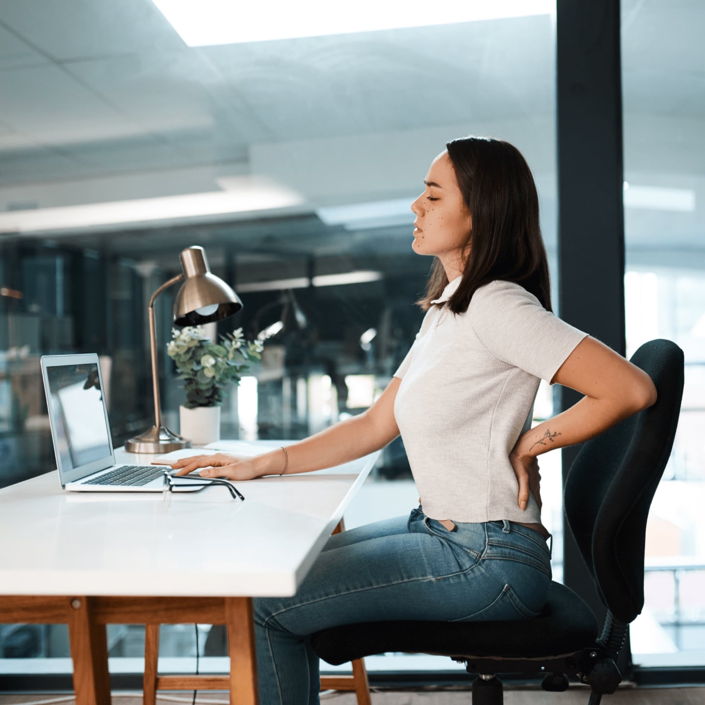 office worker holding lower back in pain